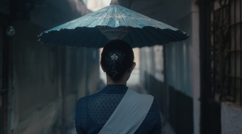 영화 나나 스틸컷 주인공 나나가 우산을 쓰고 좁은 골목길을 걸어가고 있다
