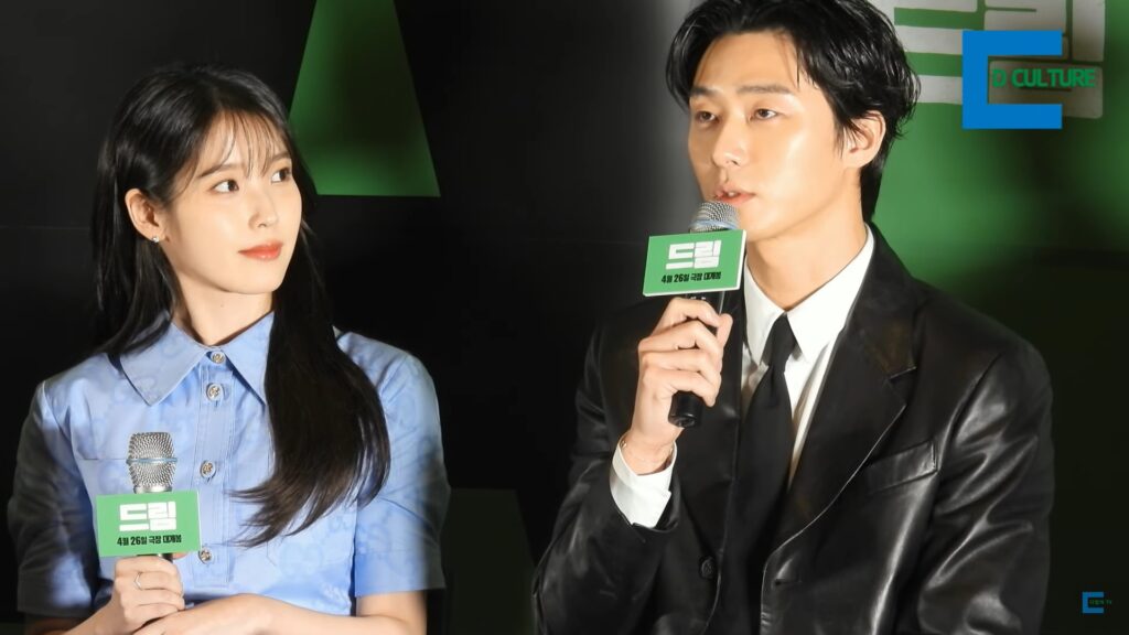 영화 드림의 기자간담회 박서준이 마이크를 들고 답변하고 있고 아이유가 박서준을 쳐다보고 있다